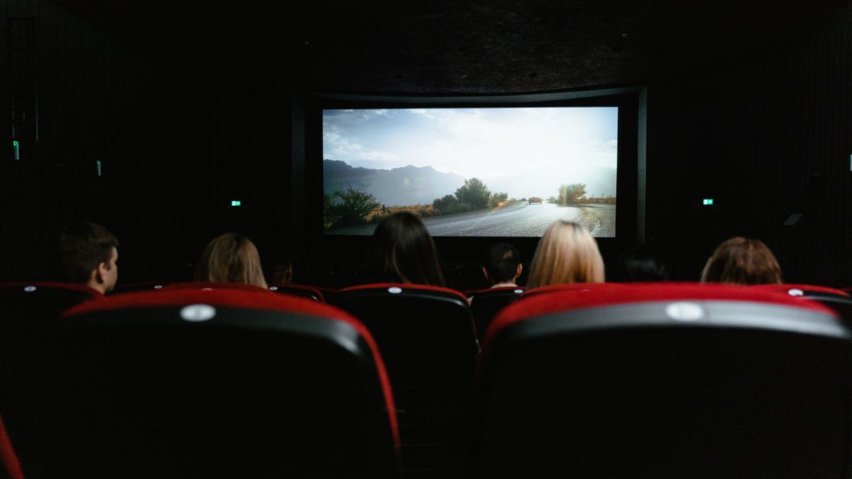 Penonton menghadap layar lebar bioskop