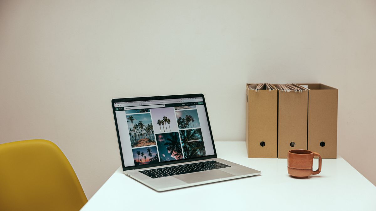 Laptop dan secangkir kopi di meja kerja