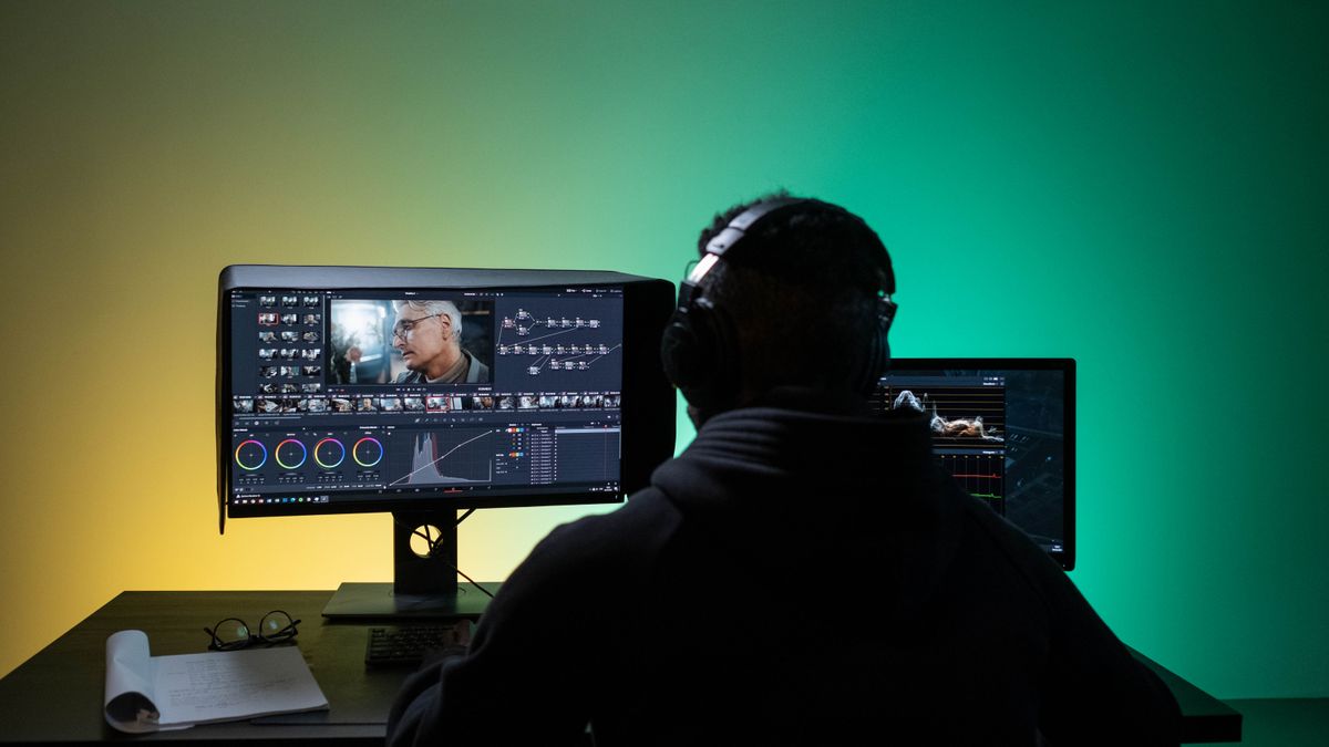 Editor video mengerjakan koreksi warna di dua monitor