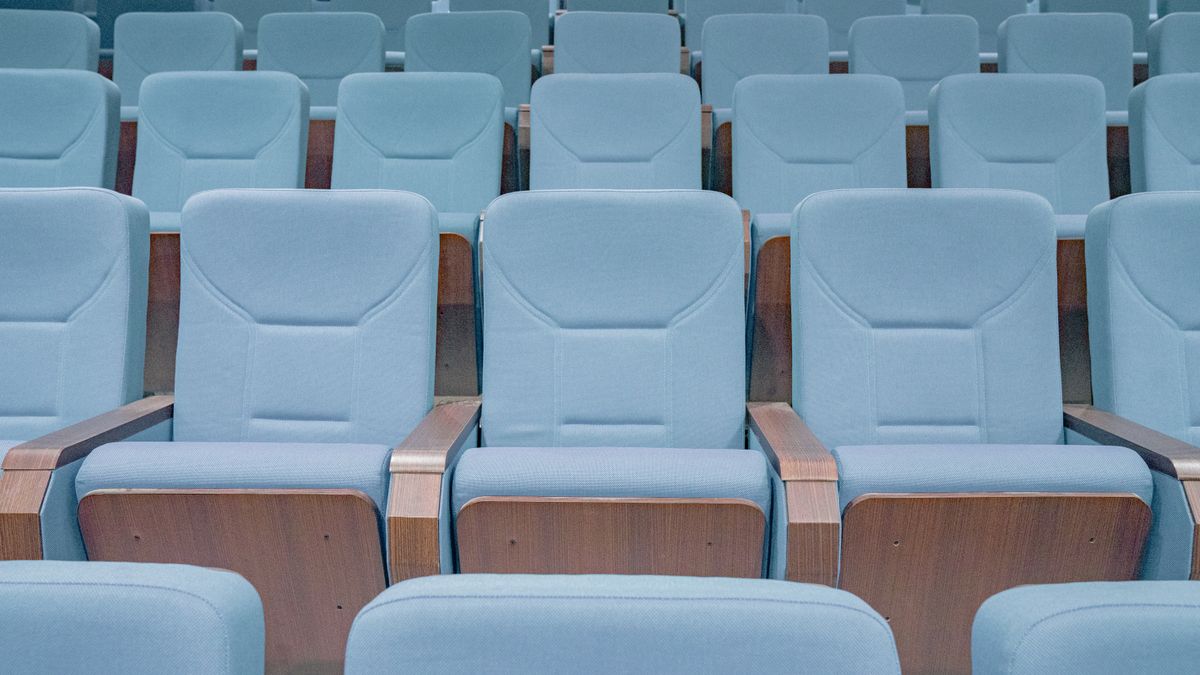 Deretan kursi bioskop biru di auditorium